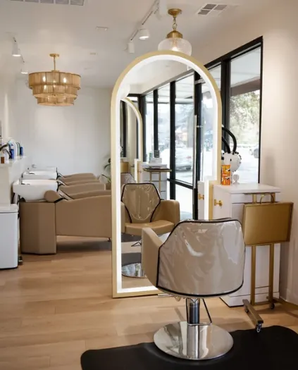 Bright Beehive Salon styling floor with gold arched mirror